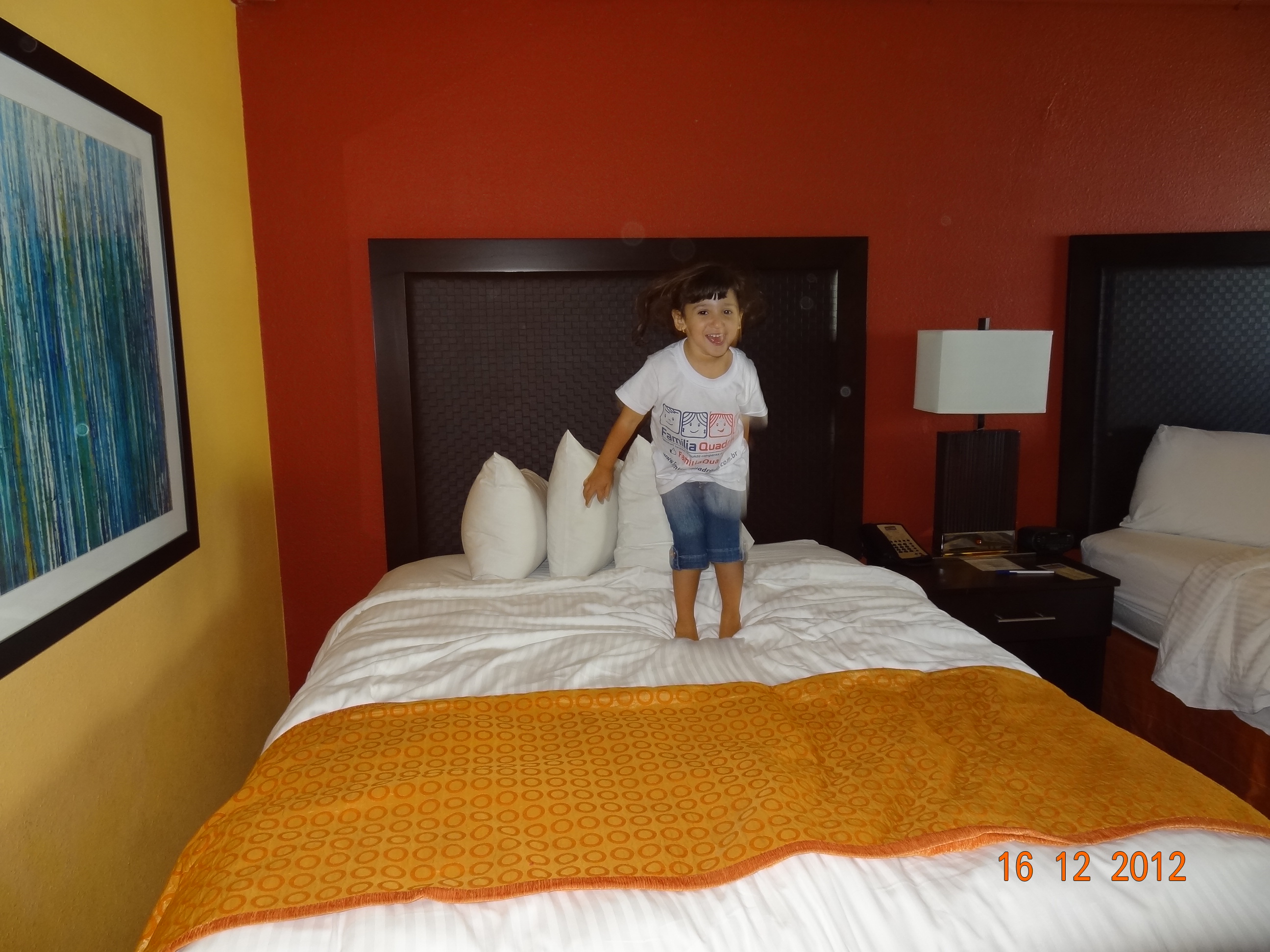 Letícia pulando de alegria na cama do hotel