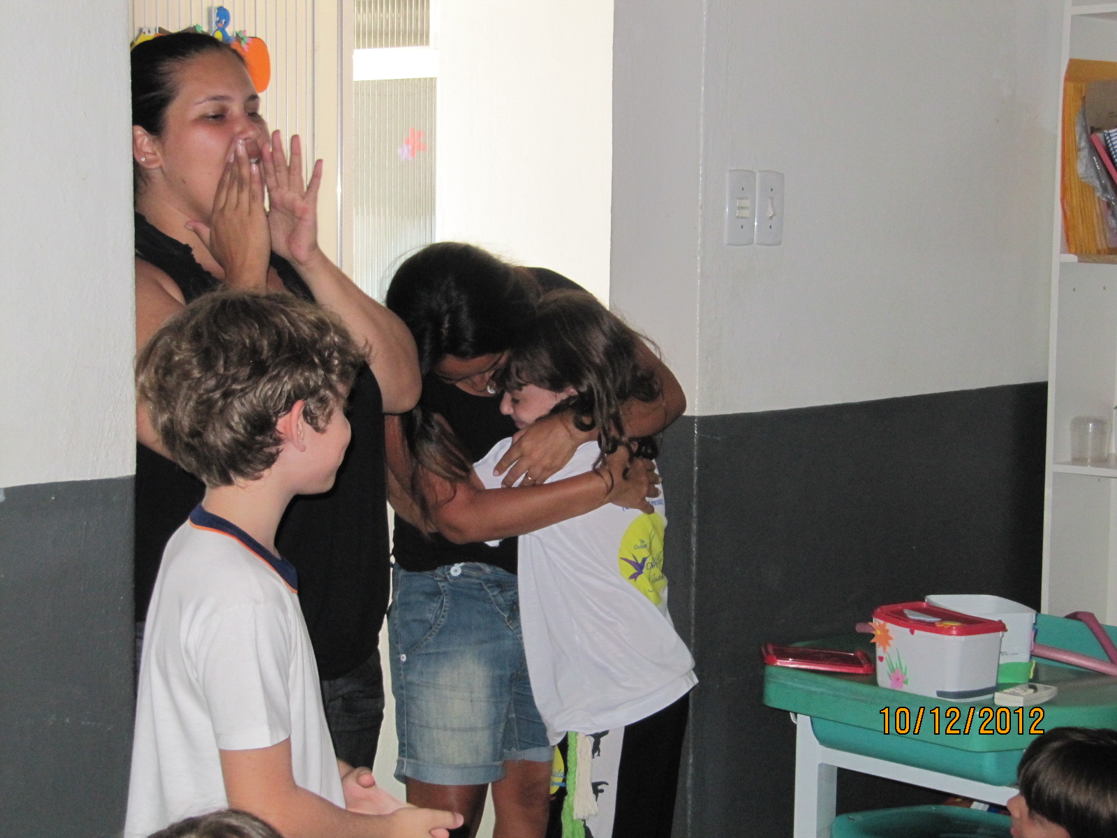 Abraçando a tia, emocionada.