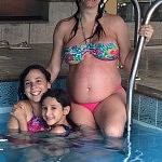 As meninas família na piscina aquecida